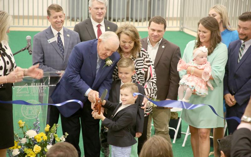 Pictured during a ribbon cutting for the new Tom McCall Agriscience Complex March 31 are (front row, L-R) Tom McCall, cutting the ribbon with help from grandsons Winn and Wilkes McCall, and Jane McCall and (back row, L-R) Technical College System of Georgia Commissioner Greg Dozier, U.S. House District 10 Rep. Mike Collins, Georgia Agriculture Commissioner Tyler Harper, Katie McCall Archer and McCall Kate Archer and Rachel McCall. (Photo by Scoggins) 