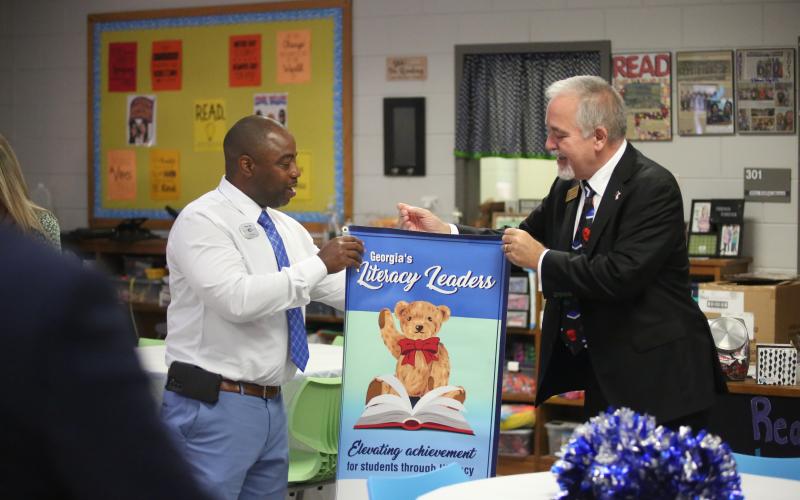 State School Superintendent Richard Woods (right) presents Elbert County Elementary School Principal Jasper Huff with a banner celebrating the school being named one of the state’s Literacy Leaders. (Photo by Wells)