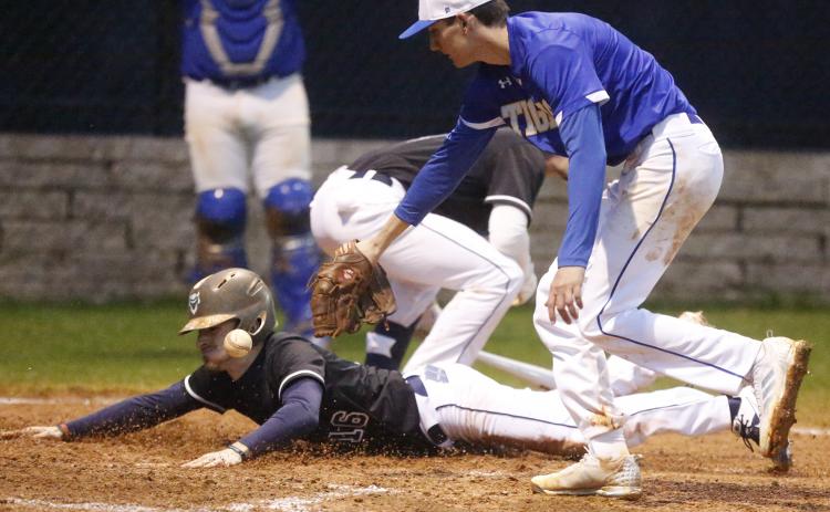 Blue Devil senior Brayden Eavenson scores as Tiger Nathan Durham (right) attempts to make a tag in the fifth inning of Elbert County’s 9-0 home-opening win over Washington-Wilkes Feb. 10 on Devils Field. (Photo by Cary Best)