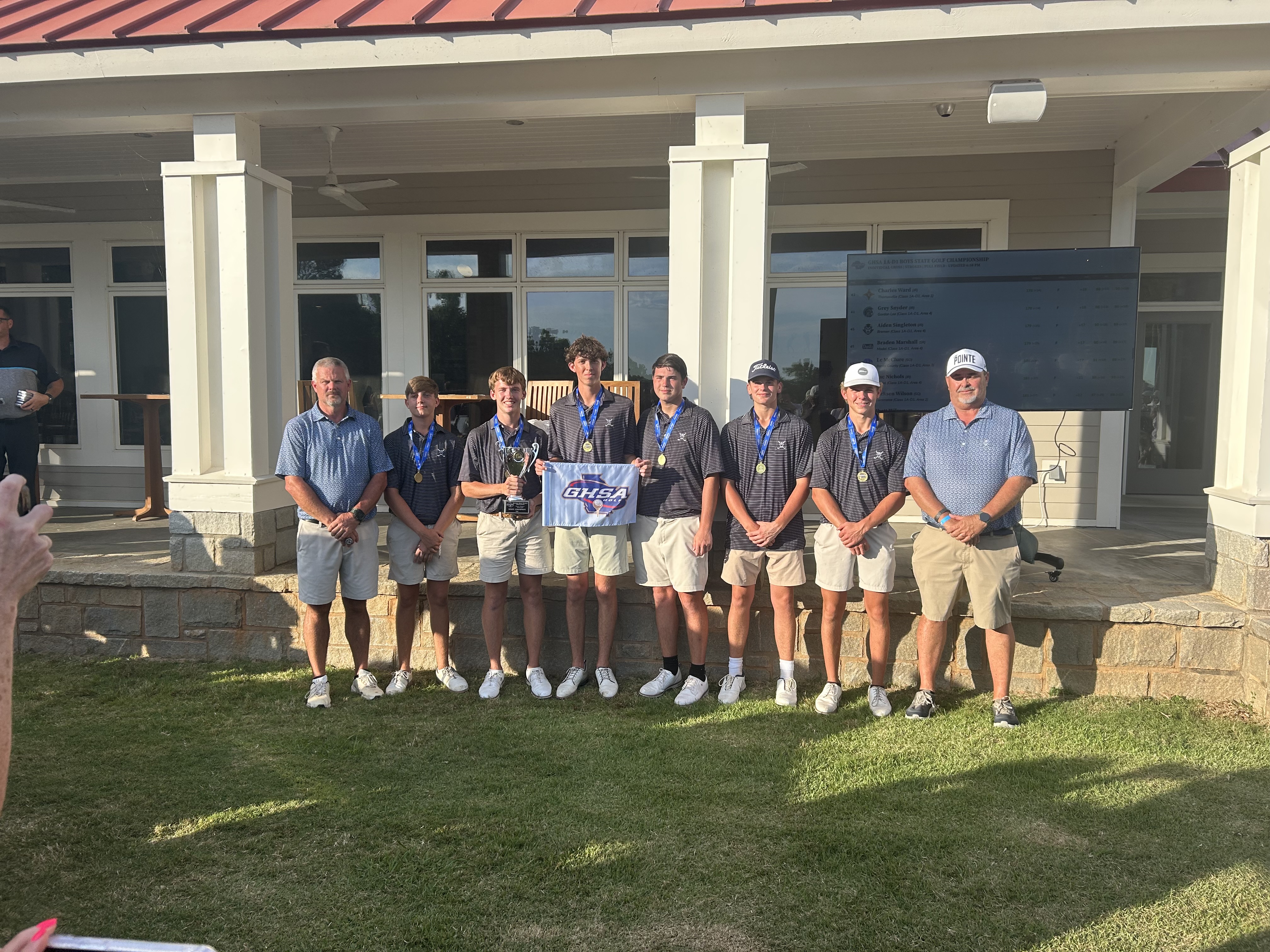 The Elbert County golf team (L-R), head coach Larry Kesler, Carson Amabile, Madden Drake, Landen Adams, Nolan Henderson, Ty Johnson, Maddox Adams and assistant coach Sandy Thornton won their second straight GHSA state championship Tuesday. (Photo by Bo Underwood)