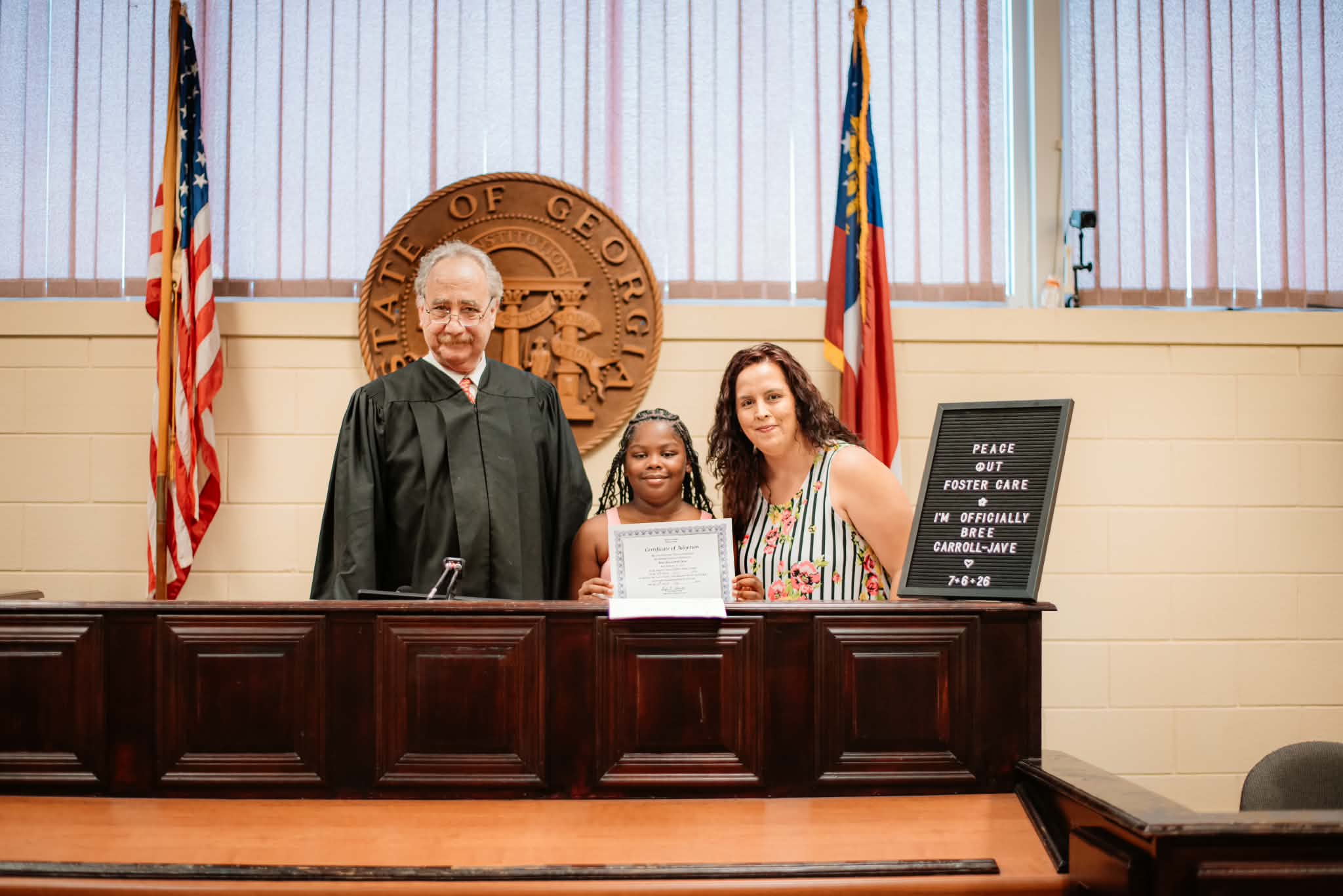 Judge Harvey Wasserman, Bree Carroll-Jave and Victoria Carroll-Jave pose for a picture in the courtroom on Bree’s adoption day. (Photo courtesy of Victoria Carroll-Jave)