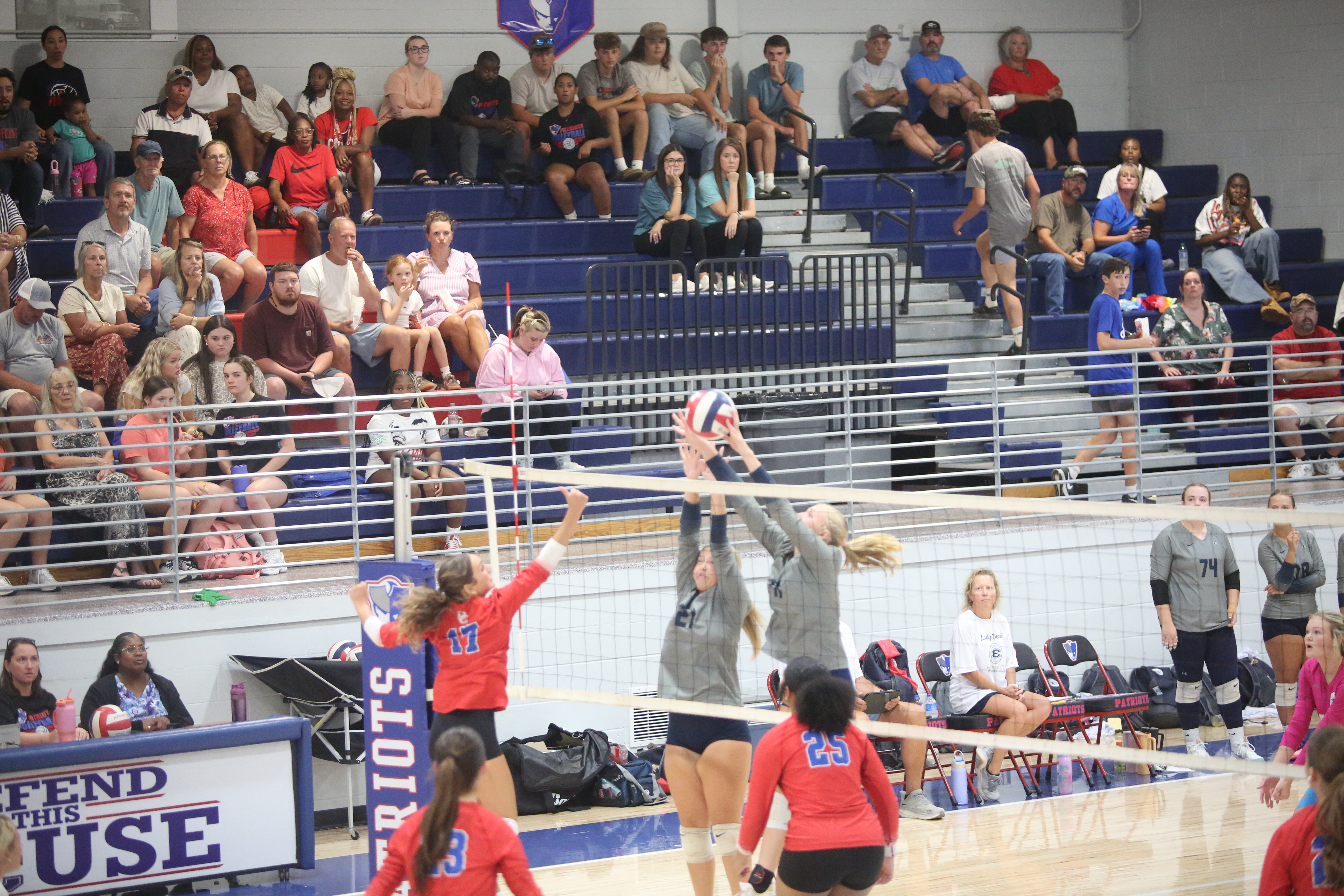 Elbert County volleyball players jump up to block the ball. (Photo by Bo Underwood)