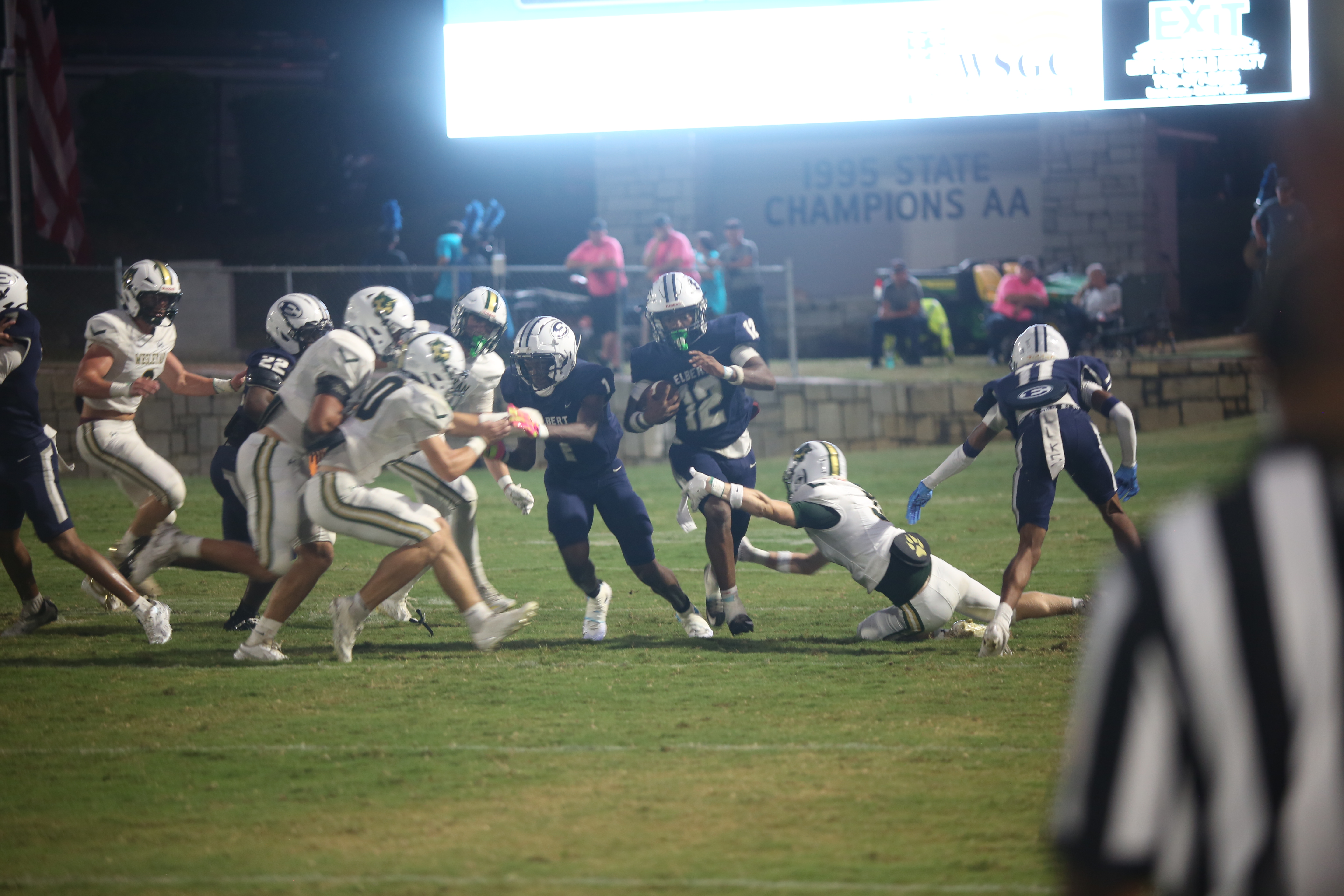 Exavier Jones (12) gets a block from Qua Cureton (1) and turns upfield. (Photo by Bo Underwood)