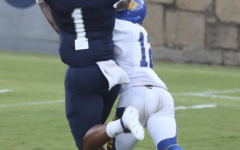 During Elbert County’s 28-14 win over Washington-Wilkes Aug. 30 in the Granite Bowl. Below, senior safety D.J. Ardister knocks down a cleat and the football while covering sophomore receiver Dalen Cobb Friday night in Elberton. (Photo by Dan Giles)