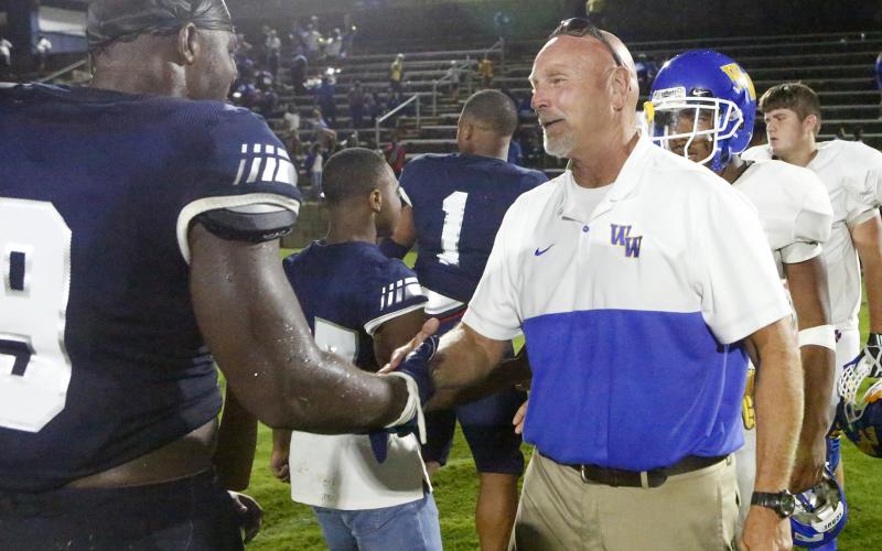 Washington-Wilkes offensive line coach and former Elbert County head coach Sid Fritts (right) shakes hands with senior Blue Devil Qwen Moss after Friday night’s game Aug. 30 in Elberton. (Photo by Cary Best)
