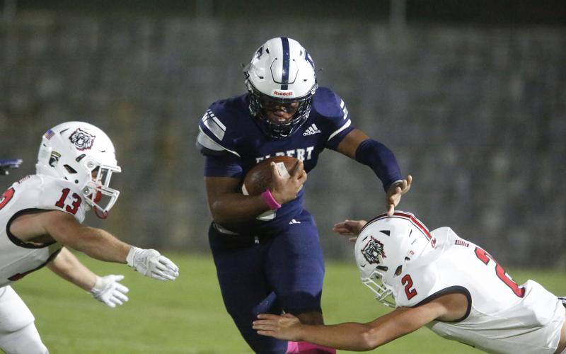 Blue Devil senior quarterback D.J. Ardister runs between two Wildcat defenders on his way to rushing for 63 yards and two touchdowns during Elbert County’s 52-15 loss to Rabun County Oct. 18 in Elberton.