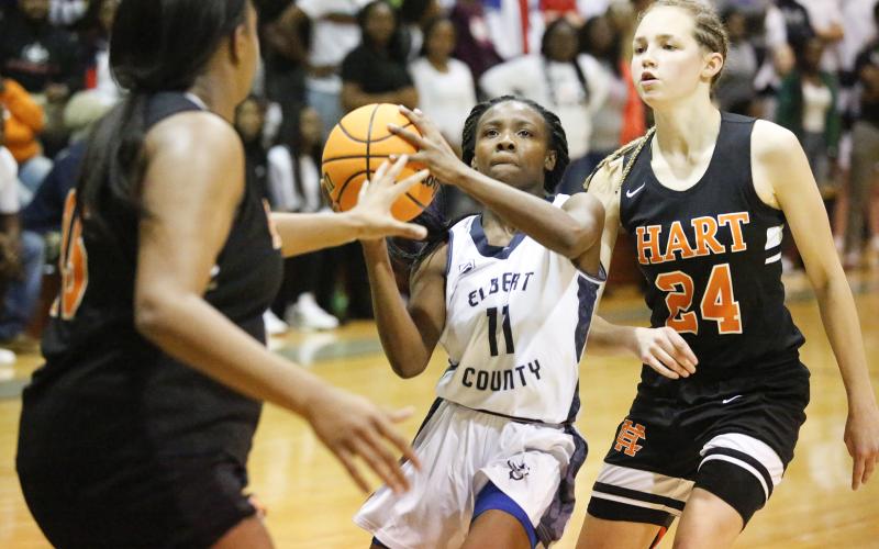 Lady Blue Devil freshman point guard Terrace Hester drives to the basket between Lady Bulldogs (L-R) Tania Alexander and Abbygail McLane in Elbert County’s 54-46 win over Hart County in the Inferno Nov. 30 in Elberton. (Photo by Cary Best)