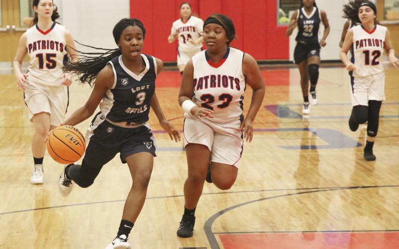 Lady Blue Devil freshman (left) drives to the basket during Elbert County’s 49-15 win at Oglethorpe High School Jan. 17 in Lexington. (Photo by Dan Giles)