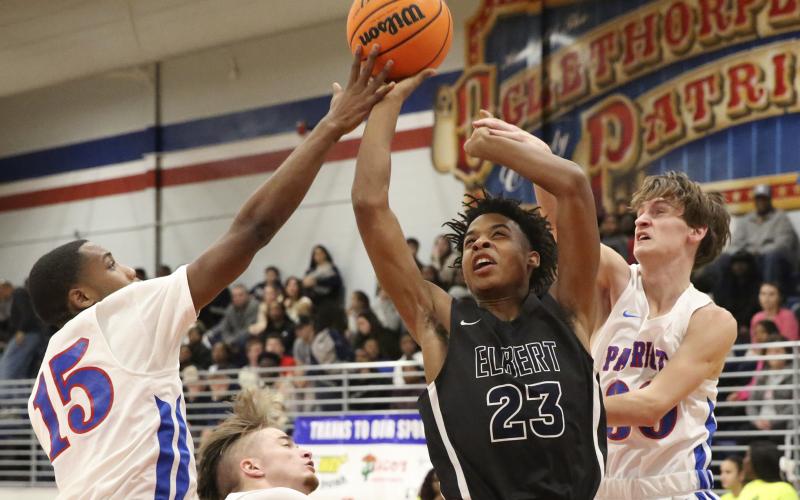 Blue Devil freshman Christian Harris (center) shoot between Patriot defenders during Elbert County’s 76-37 region win at Oglethorpe County Jan. 17 in Lexington.(Photo by Dan Giles)