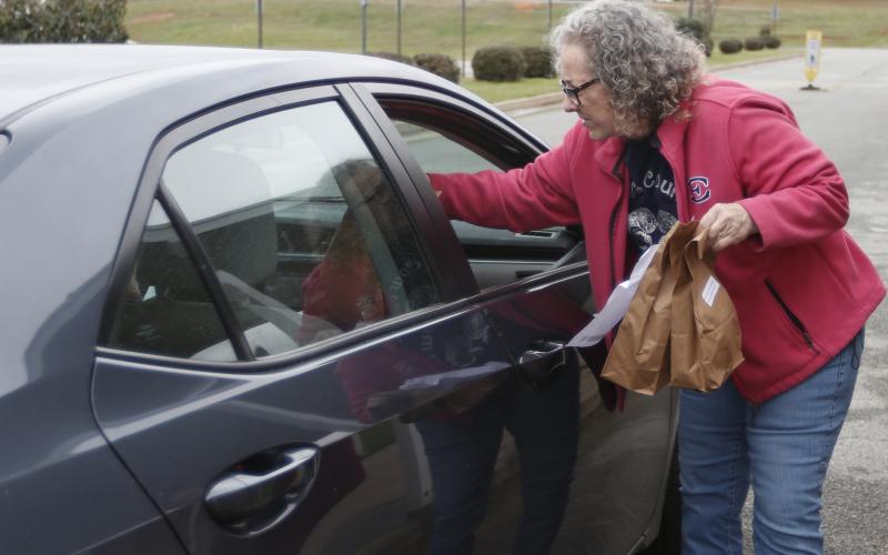 Barbara Bennett assists in distributing lunches called ‘Grab and Go’ at Elbert County Middle School. All schools are preparing student meals for students despite school closures in Elbert County. (Photo by Scoggins)