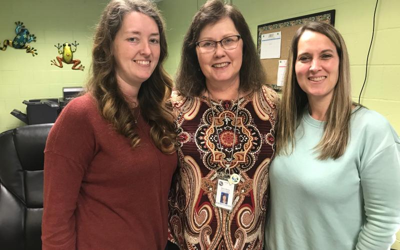 Rosa Harris (center) gets daily assistance from front office staffers Amber Vaughn (left) and Jeannie Vaughn (right). (Photo by Jones)