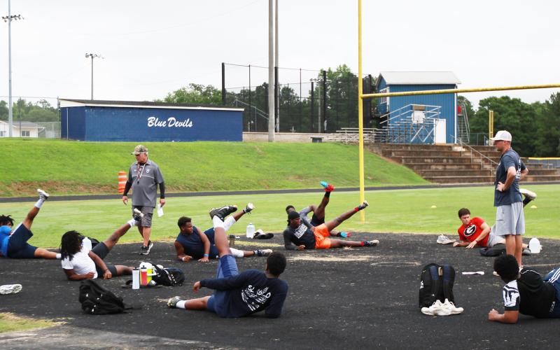 Elbert County football coaches Tommy Gilstrap (left) and Reuben Haynes (right) work with Blue Devil football players during voluntary player workouts Monday morning. Two groups of players worked out on Monday morning under guidelines issued by the state and the Center for Disease Control. (Photo by Scoggins)