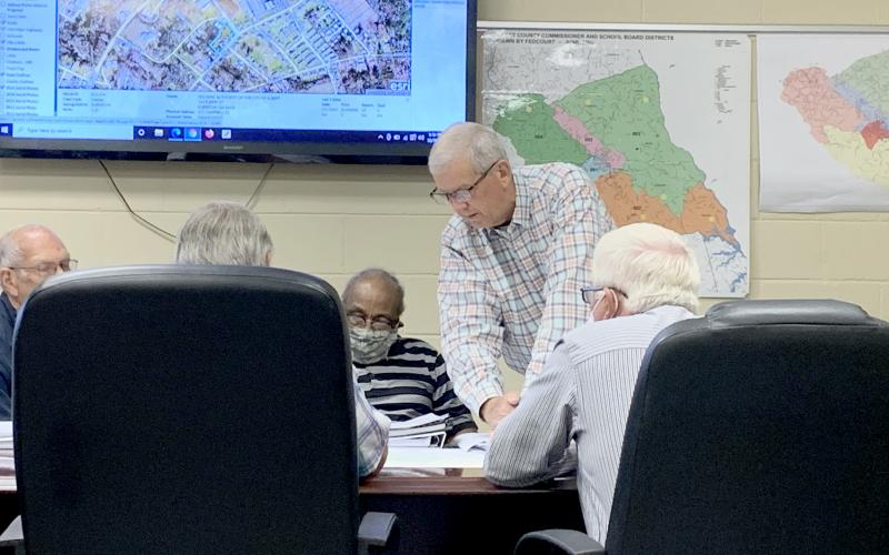 County Administrator Bob Thomas (center) shows the Elbert County Board of Commissioners the first draft of a map that would redraw the county’s districts during the BOC’s work session Thursday, Oct. 7. The county is expected to vote on whether or not to redistrict the county by Nov. 2. (Photo by Scoggins)