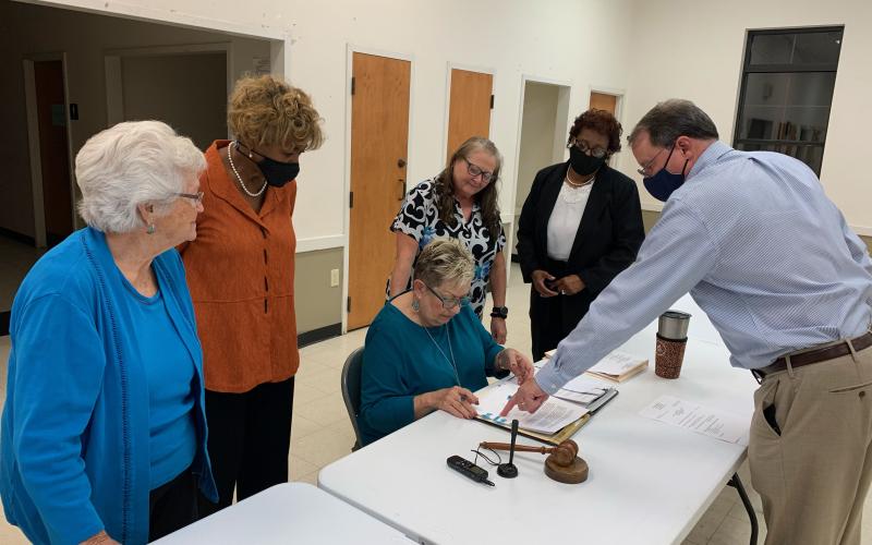 City Attorney Richard Campbell (far right) shows Mayor Roberta Rice (middle) where to sign to officially enter into an agreement with theGeorgia Environmental Finance Authority for a $1 million loan from the Drinking Water State Revolving Fund that will improve the city’s water system and could be see forgiveness of over half of the loan. Watching Rice sign the agreement were (L-R) council members Betty Jo Maxwell, Mary Clark, city clerk Cynthia Johansen and Henrietta Williams. (Photo by Scoggins)