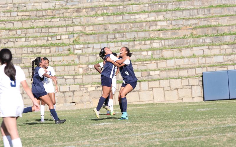 Left, Lady Devils Victoria Medellin and Hannah Halavin celebrate a goal during the team’s win over Elite Scholars Academy in the first round of the GHSA playoffs. (Photo by Wells)