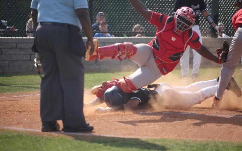 Therell’s catcher falls on Diamond Devil Trustin Allen after he slid safely into home plate during the first round of the GHSA state playoffs at Diamond Devil field Friday, April 29. (Photo by Scoggins)