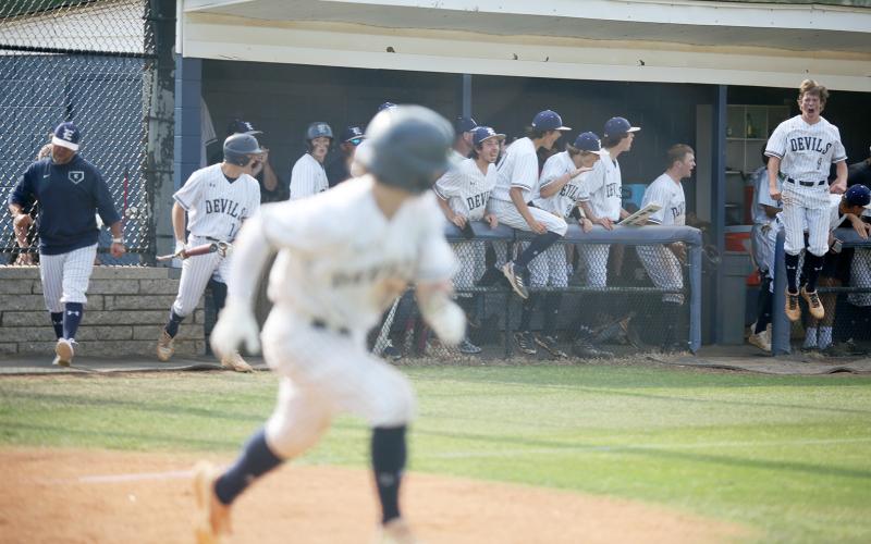 Senior Cole Hudson doubled during the first game against the Jeff Davis Yellow Jackets Wednesday, May 4 to score the first run of the game by fellow senior Carson Adams. Senior Caden Brown (right) and the Diamond Devils react to Hudson’s hit as he runs towards first base.