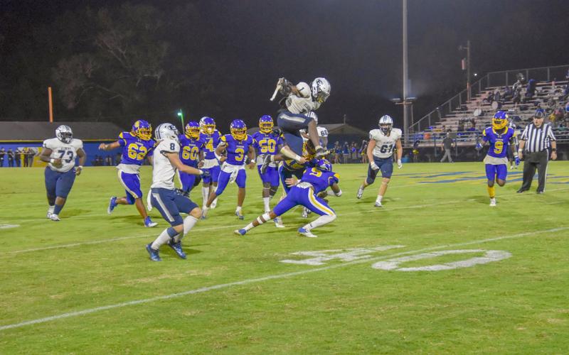 Senior Quan Moss hurdles over a Washington-Wilkes Tiger during Friday’s 32-20 win over the No. 5-ranked Washington-Wilkes High School in Washington.