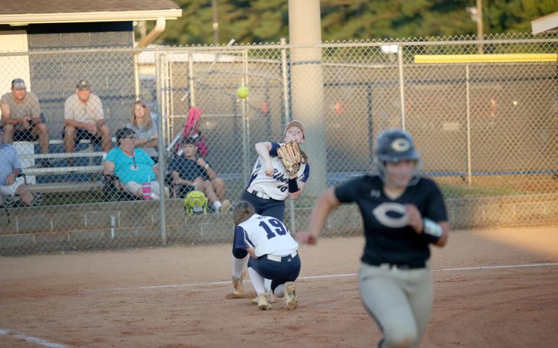 Senior Lilly Ray throws a ball to first base in an attempt to tag a Commerce runner out during the Lady Devils’ region win Sept. 20. (Photo by Wells)