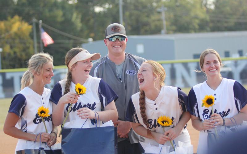 Lady Devil softball seniors (L-R) Jaynee Webb, Lilly Ray, Ava Lunsford and Emalise Andrews laugh during the senior recognition before the team’s final regular season home game Tuesday, Oct. 11. The four seniors were joined by Head Coach Drew Greer. (Photo by Wells)