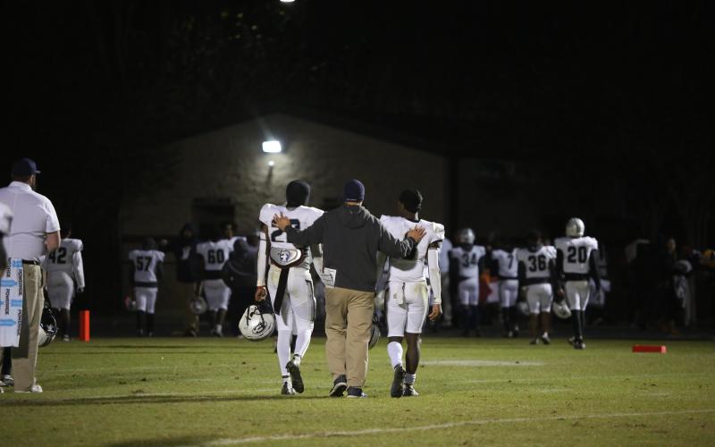 Assistant Coach Mike Williams walks off Prince Avenue’s field with sophomores Malik Hill (left) and Jermaine Sims (right) after the Devils’ 48-14 seasoning-ending loss Nov. 18.