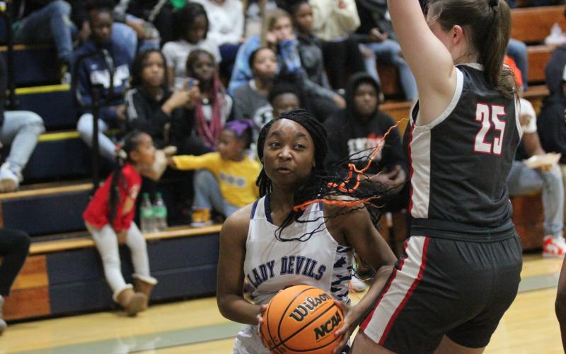 Junior Aameriah Allen dives under a Madison County defender on her way to the basket during the win over Madison County Dec. 9. (Photo by Wells)