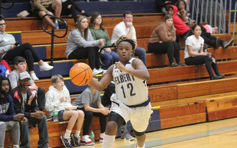 Eighth grader Exavier Jones takes the ball down the court against Stephens. (Photo by Wells)