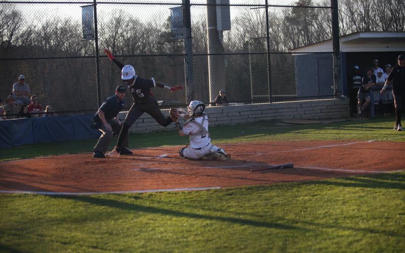Devil catcher Camden Bryant attempts to tag a Tallulah Falls runner out as he leaps over home plate during the Devils 7-6 win over the Indians March 9. (Photo by Wells)