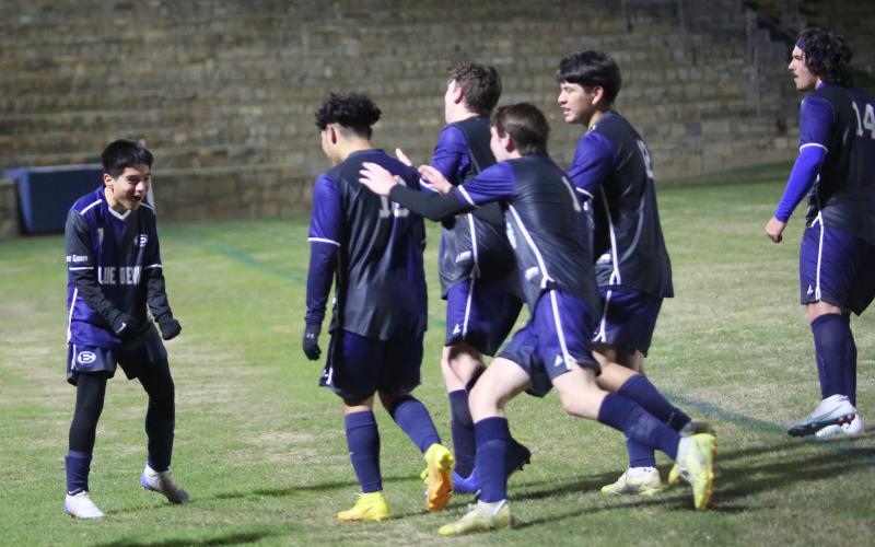 A group of Blue Devils celebrate with teammate Pablo Medellin (left) following the team’s 4-3 overtime win over Rabun County March 14 in the Granite Bowl. The win put the Devils in second place in the region. (Photo by Wells)