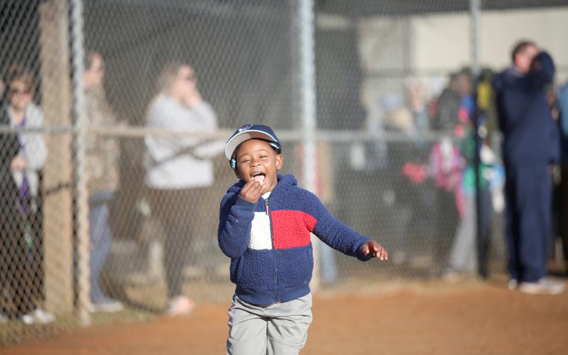 During the parade, Hooks t-ball team member Ah’Miracle Thompson (right photo) enjoyed a bite of a pre-game snack. (Photo by Wells)