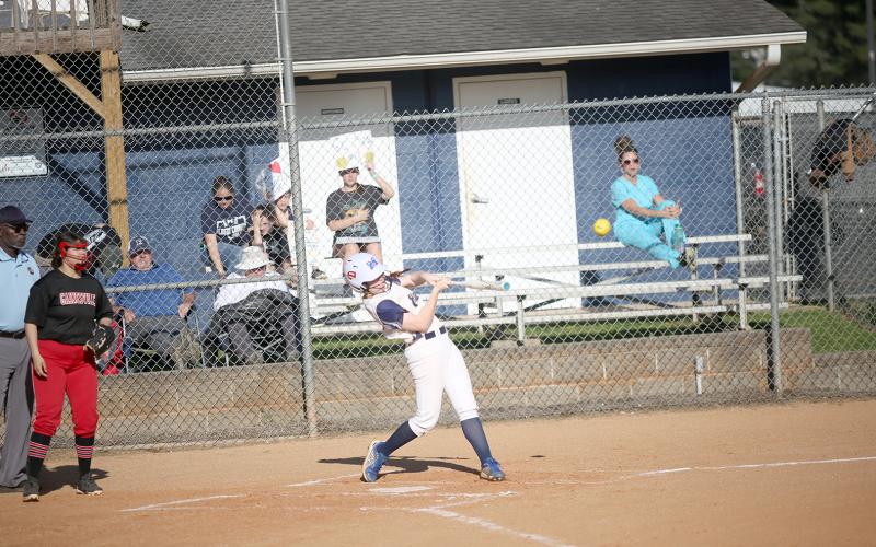 Senior Ava Lunsford drills a ball into the outfield during the Lady Devils game against Gainesville March 29. (Photo by Wells)