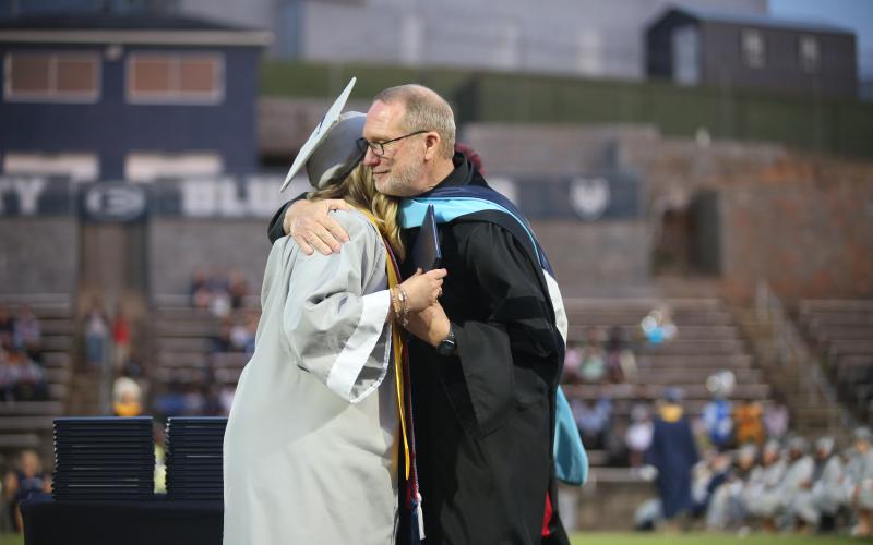 Former superintendent Jon Jarvis hugs his niece, Emma Grace Jarvis, after handing her her diploma as the valedictorian for the Elbert County Comprehensive High School Class of 2023. The May 26 graduation was Jarvis’ last event as superintendent. (Photo by Scoggins)