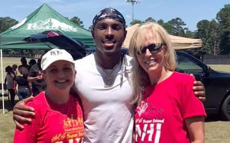 The Friends Helping Friends annual Football Fun Day with Mecole Hardman will take place Saturday, June 17 from 9 a.m. until noon. Pictured during the 2022 event are (L-R) Devon Davis, Hardman and Sandy Adams.
