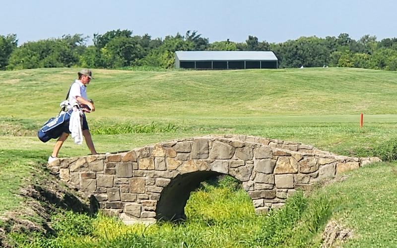 Elbert County Blue Devil senior Brady Starrett walks across a bridge at the Tribute Links Course in Frisco, Texas during the 2023 Boys High School Golf Invitational. The bridge is made to look identical to the famous No. 18 hole of the historic St. Andrews Links.