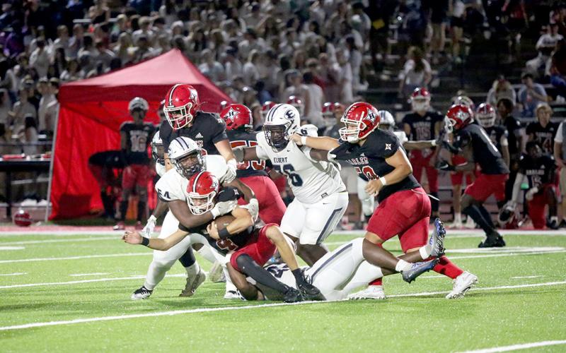 No. 54 Seneca Turner and No. 42 D.J. Fortson wrap up the Harlem quarterback in the backfield late in the game. (Photo by Wells)