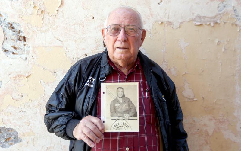 Elberton’s John N. “Pete” Anderson, 88, holds a photo of him taken aboard a ship at Fort Lewis, now Joint Base Lewis-McChord in Tacoma, Washington before being shipped off to Korea in 1958. (Photo by Scoggins)
