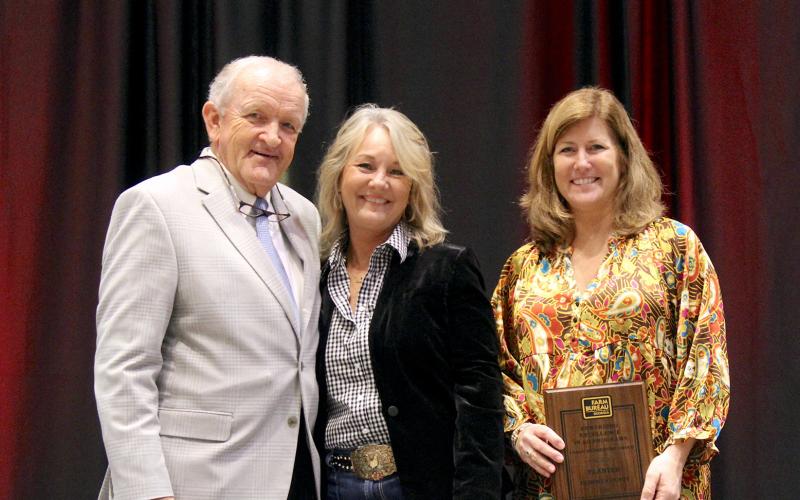 From left, Georgia Farm Bureau (GFB) President Tom McCall presents Elbert County Farm Bureau (ECFB) President Mandy Williams and ECFB Office Manager Haley Oakley with a GFB Rewarding Excellence in Ag Program Planter Award in the organization’s large membership division. The award was presented on Dec. 4 during the 86th Annual Georgia Farm Bureau Convention held on Jekyll Island.