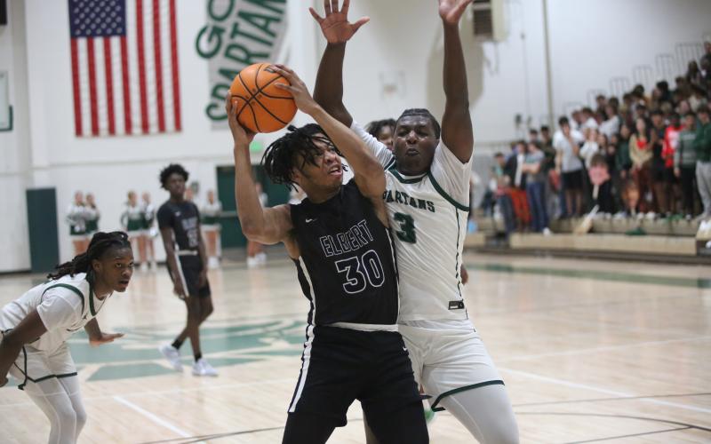Landon Hill absorbs contact and goes to the basket during Elbert’s loss to Athens Academy. (Photo by Wells)