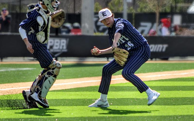 No. 26 Landon Adams gathers the ball and throws to first as Camden Bryant looks on during the GA Dugout Club Tournament. (Photo courtesy of April Dixon Hughes)