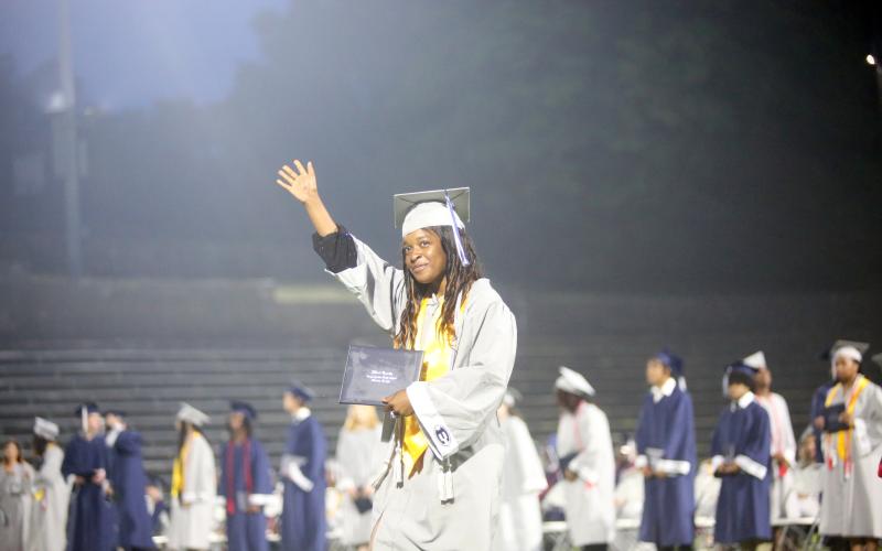 ECCHS senior De'Asia Kinsey waves to the crowd as she proudly displays her diploma during the May 24 graduation ceremonies in the Granite Bowl.  (Photo by Wells)