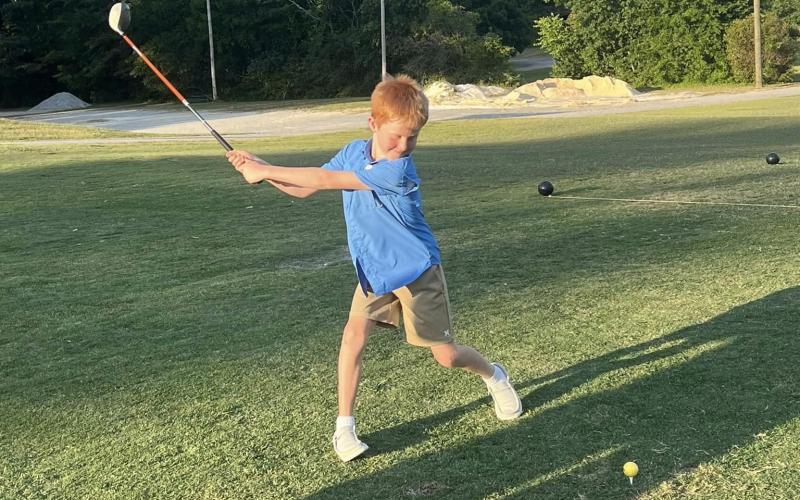 Youth golfer Benson Holland takes a swing at the ball during the Elbert County Future Blue Devil Golf Camp held June 17, June 18 and June 20. (Photo courtesy of Larry Kesler)