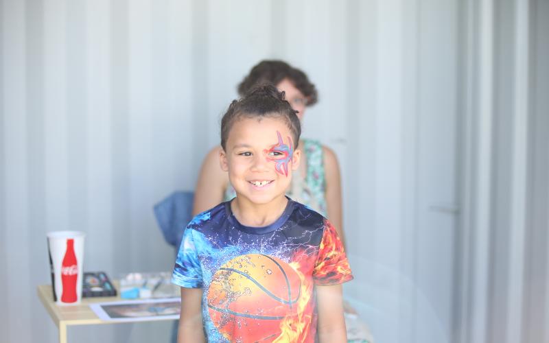 a happy customer poses for a picture after getting his face painted. (Photo by Wells)