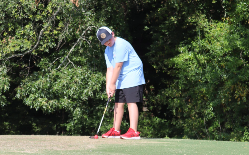 Carson Johnson lines putts on the green during the Future Blue Devil Camp. (Photo by Weeks)