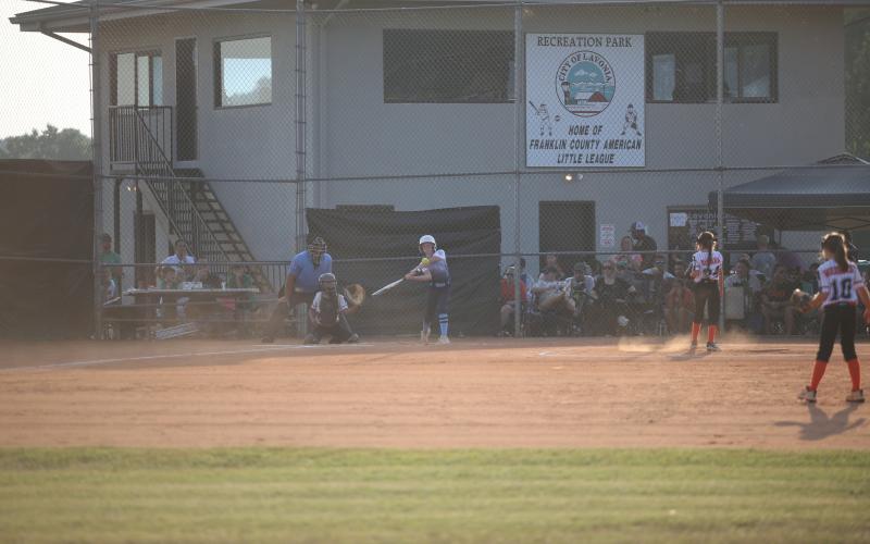 Skylar White puts the ball in play before running to first base in Elbert’s June 27 matchup with Hart County. (Photo by Wells)