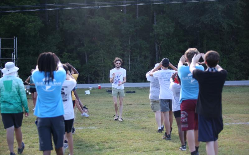 Low Brass Instructor Mason Christmas leads the low brass in a marching drill during band camp. (Photo by Wells)