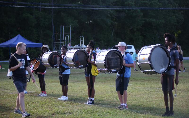 Percussion Instructor Marshall Robinson (far left) looks on while percussionists (L-R) Keon Baker, Attorian Small, Nadia Hughes, Landon Bowman and JaQuan Burton practice a marching movement during band camp. (Photo by Wells)