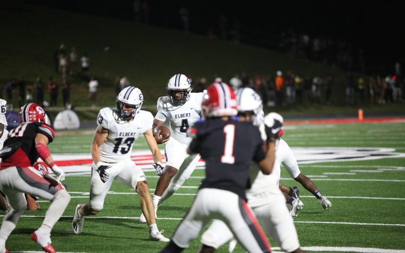 Below, No. 4 Jayvyn Hickman looks for a hole while No. 13 Brady Dickerson lead blocks during Elbert’s game against Stephens. (Photo by Wells).
