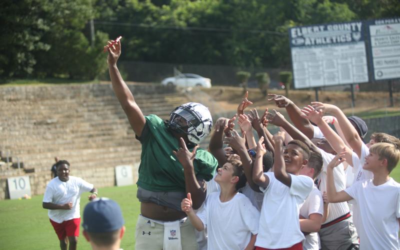 Left, Quarterback Jayvyn Hickman (far left) takes a selfie with a host of young Devil fans using one of the fans’ phones during last year’s Community Kickoff. (File photo by Wells)