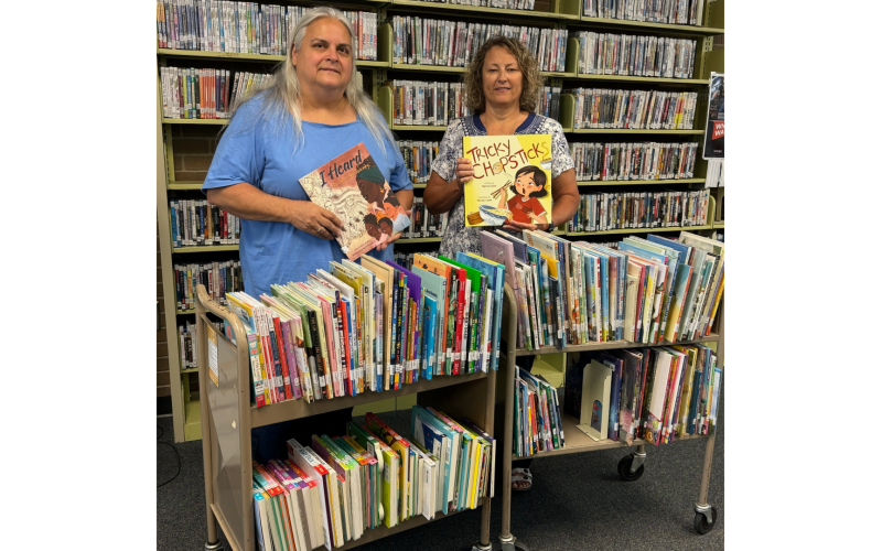 Elbert County Librarian Jan Burroughs and Elbert County School L4GA Coordinator Thesa  Beatenbough display some of the 260 titles purchased for the library by the school district’s L4GA grant to fund literacy in Elbert County. (Photo submitted by Jan Burroughs)