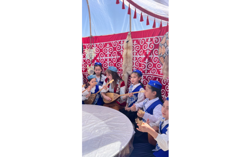 Anna celebrates Nowryz (Persian New Year) in a the traditional manner in the village of Zhanga-Korgan. Here the girls are teaching her to play the Kazakh traditional folk instrument, called the dombyra. The hat she is wearing was handmade by them. (Photo submitted by Anna Kubas)